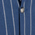 Close-up of a blue and white striped fabric with a button.