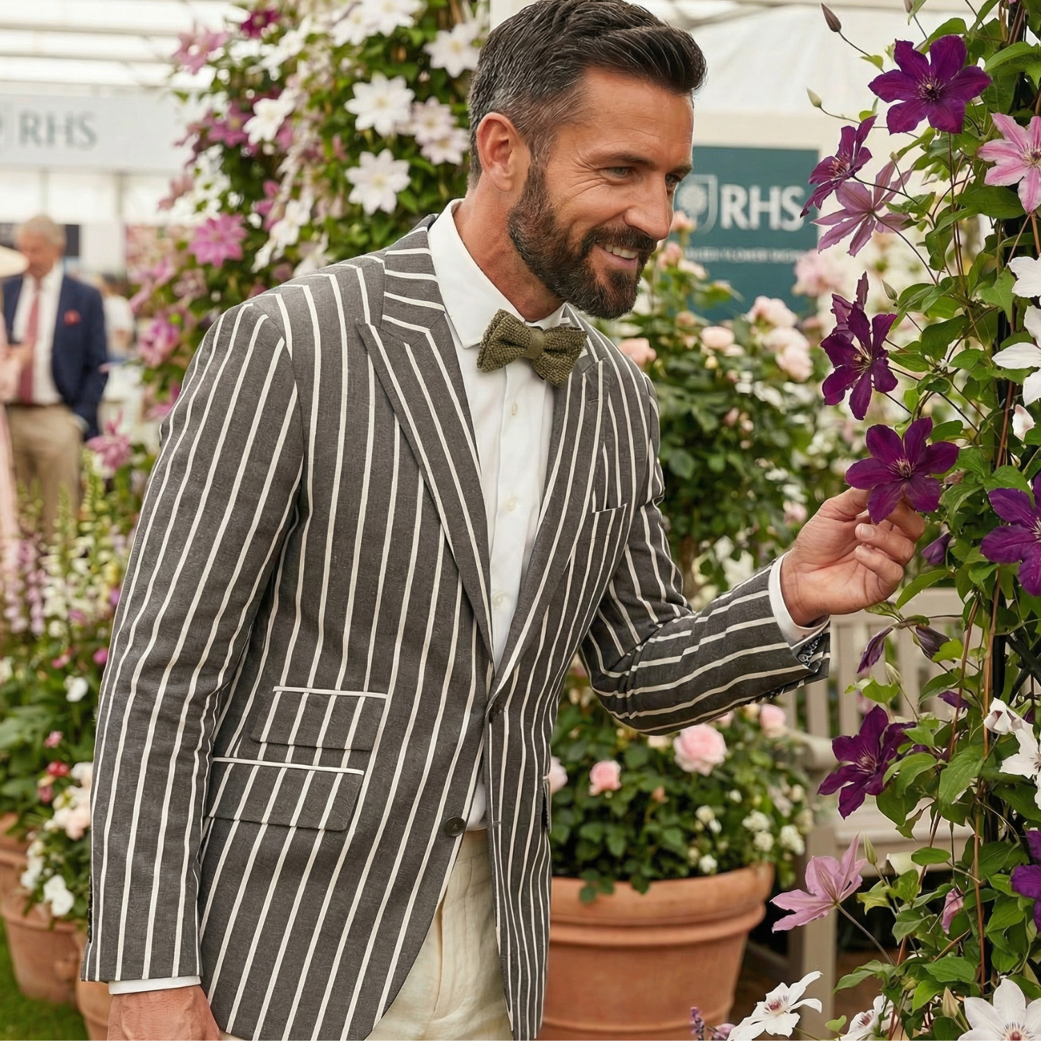 Man in a striped suit examining flowers at an RHS event